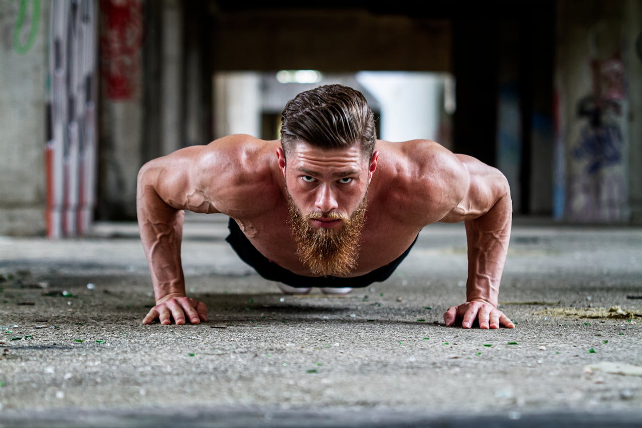 Crafting Captivating Headlines: Your awesome post title goes here Fit shirtless man with a beard doing a push-up exercise on concrete floor.